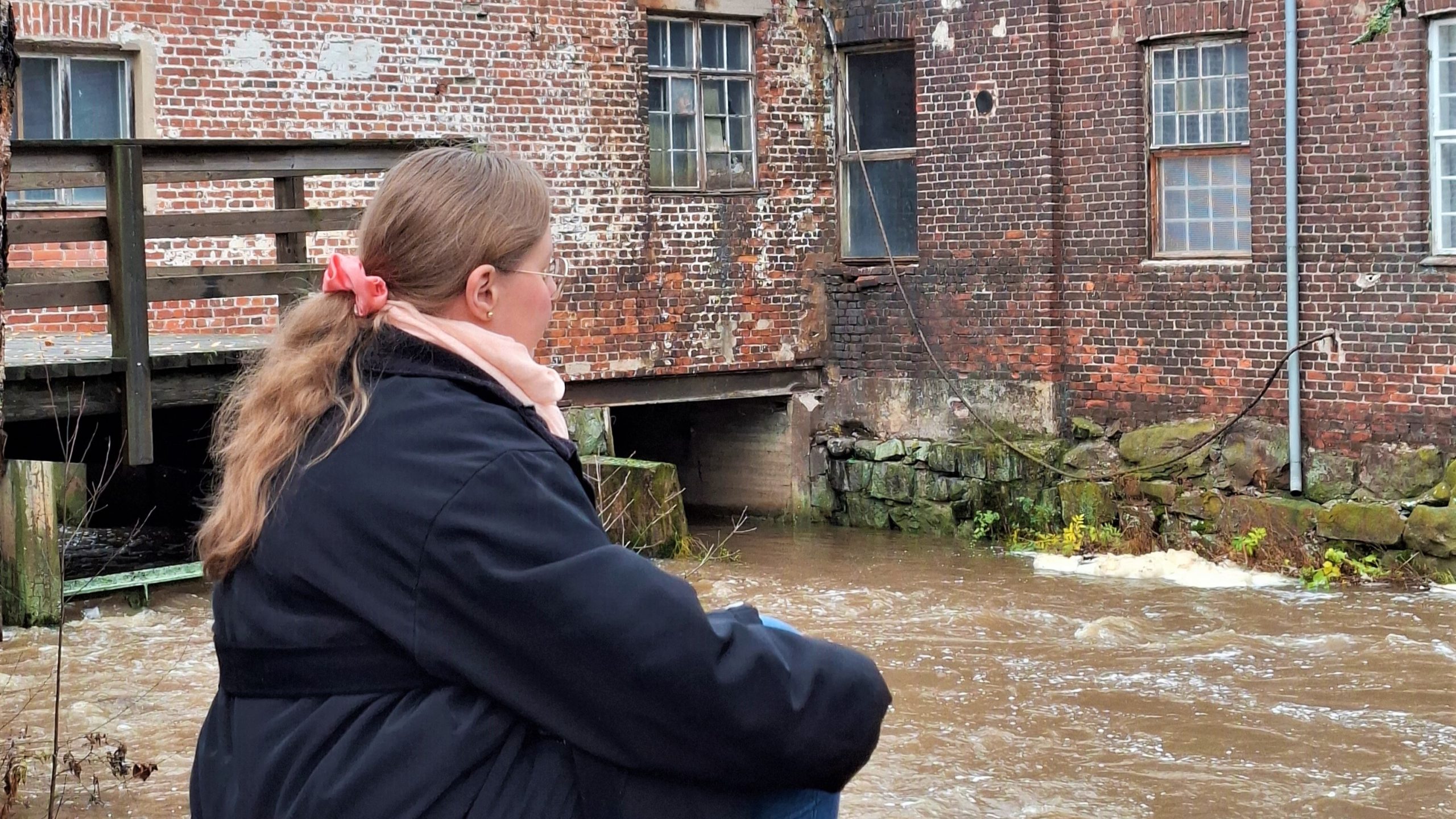 Oivallus Akatemia, Hanna Poikkilehto. Aikalisä. Nainen istuu Kellokoskella kosken rannalla ja katsoo koskea.